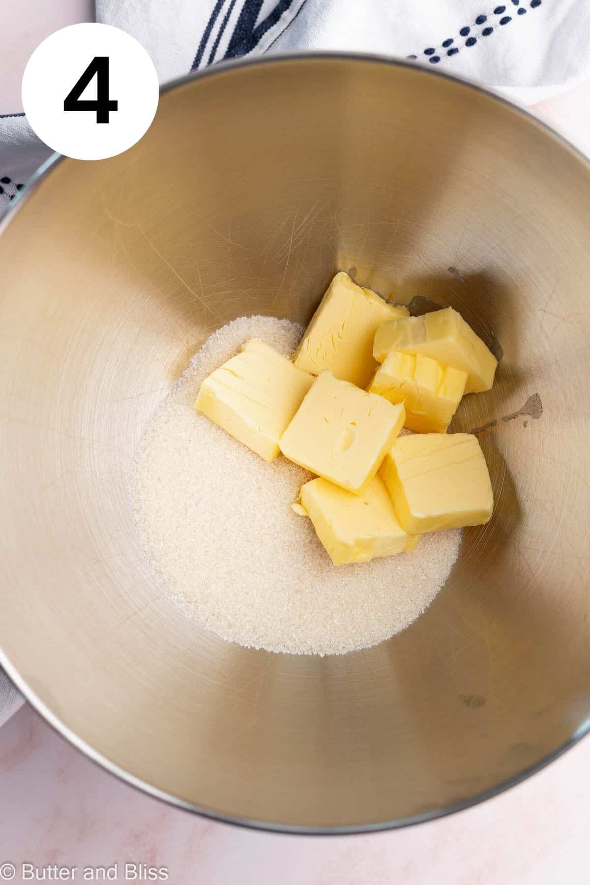 Sugar and butter cubes in a mixing bowl.