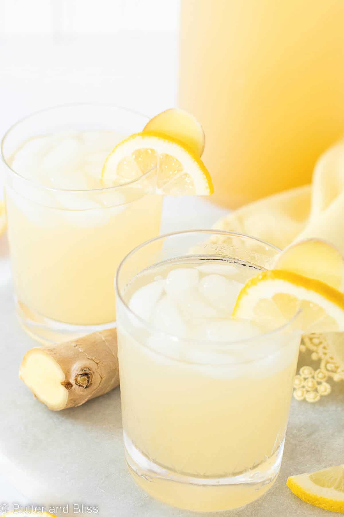 Two glasses of ginger lemonade with lemon wedges