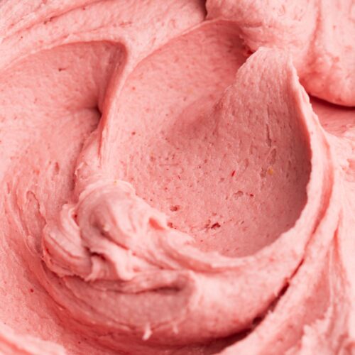 Creamy strawberry buttercream frosting in a bowl.