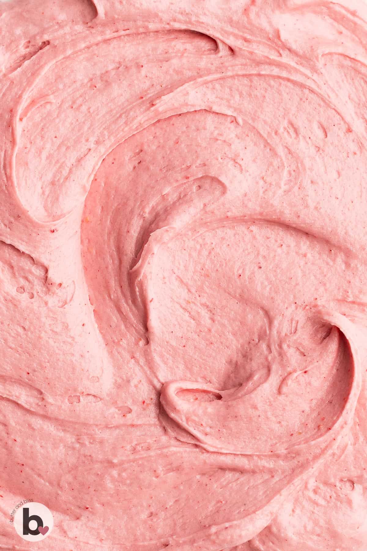 Swirls of strawberry buttercream on a plate.