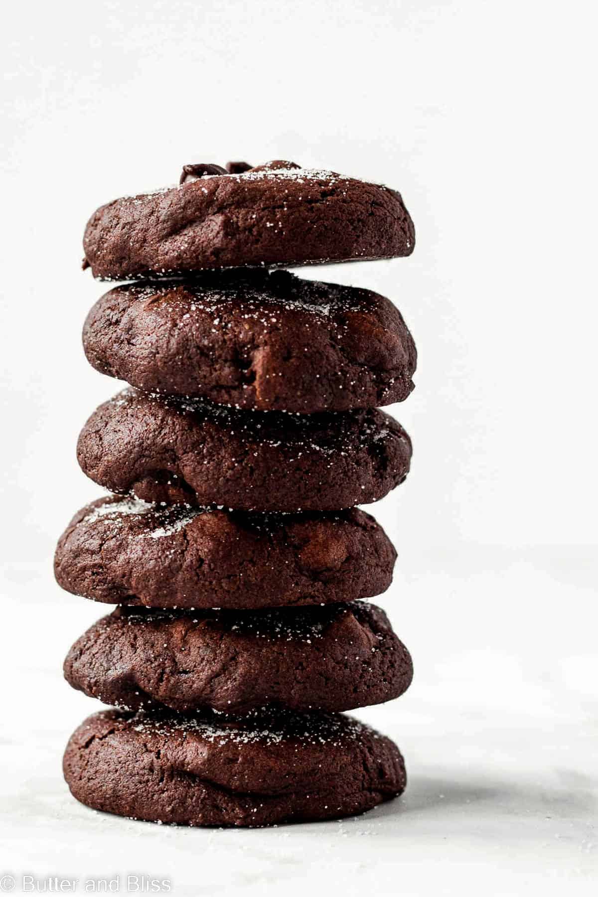 Towering stack of double chocolate cookies on a table.