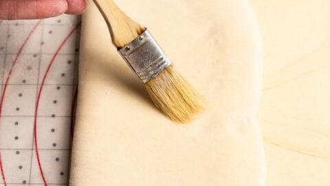 Croissant dough being folded into a letter fold.
