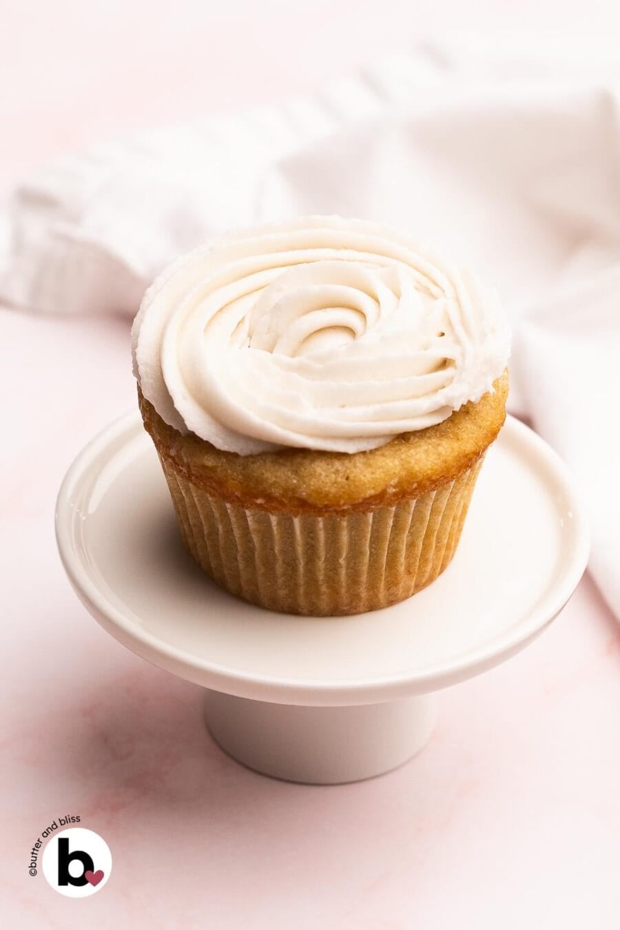 Cupcake with a swirl of vanilla frosting without butter on top.