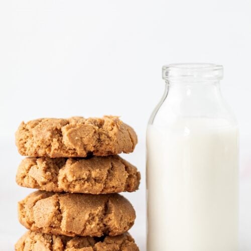 A pretty stack of flourless peanut butter cookies next to a glass of milk.
