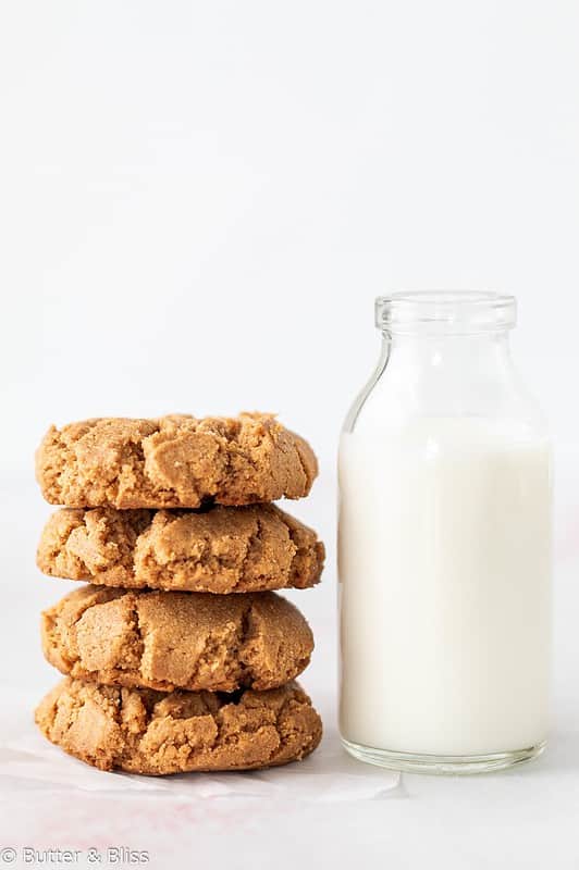 A pretty stack of flourless peanut butter cookies next to a glass of milk.