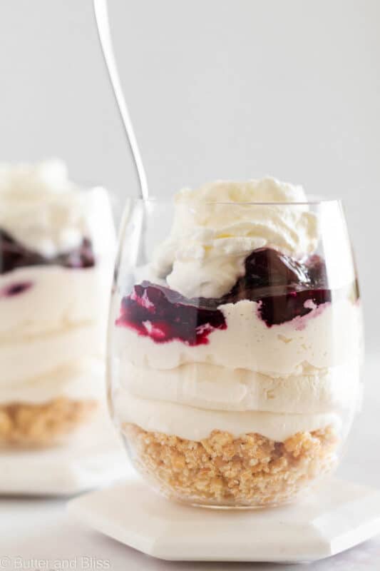 Cherry cheesecake parfait in a parfait glass with a spoon