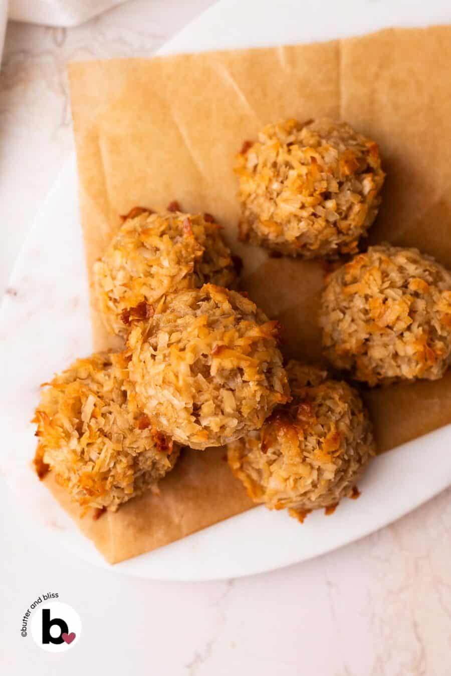 Small batch coconut maple macaroons stacked on a marble plate.