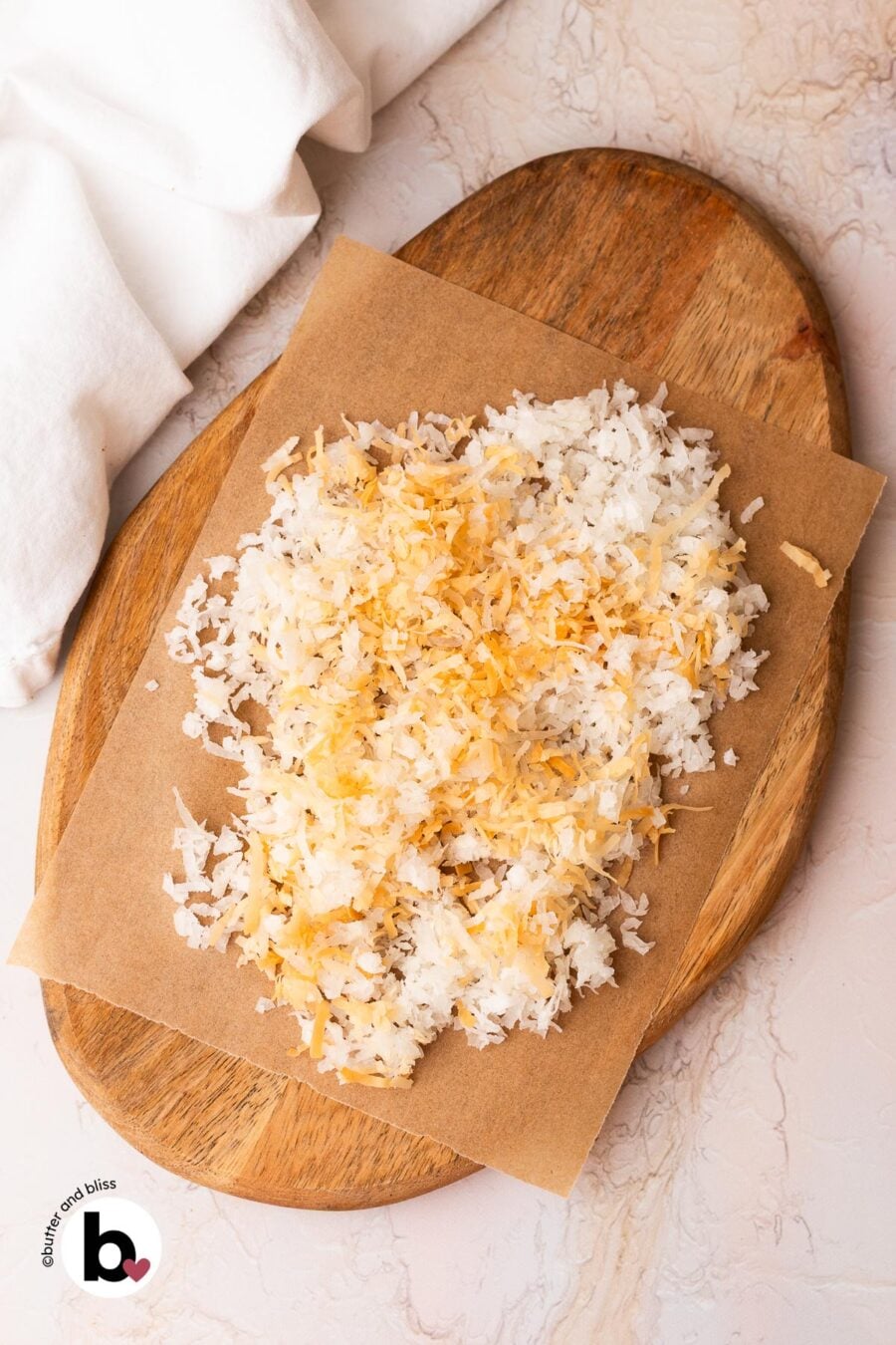 Roughly chopped toasted coconut and shredded coconut on a wood cutting board.