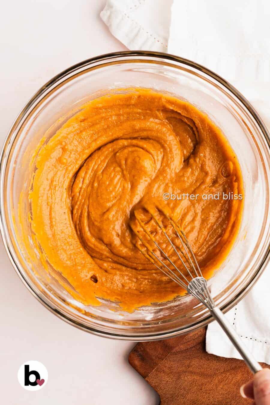 Smooth pumpkin bread batter being mixed in a bowl.