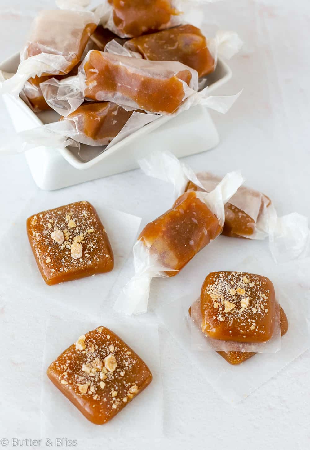 Homemade apple cider caramels arranged on a table.