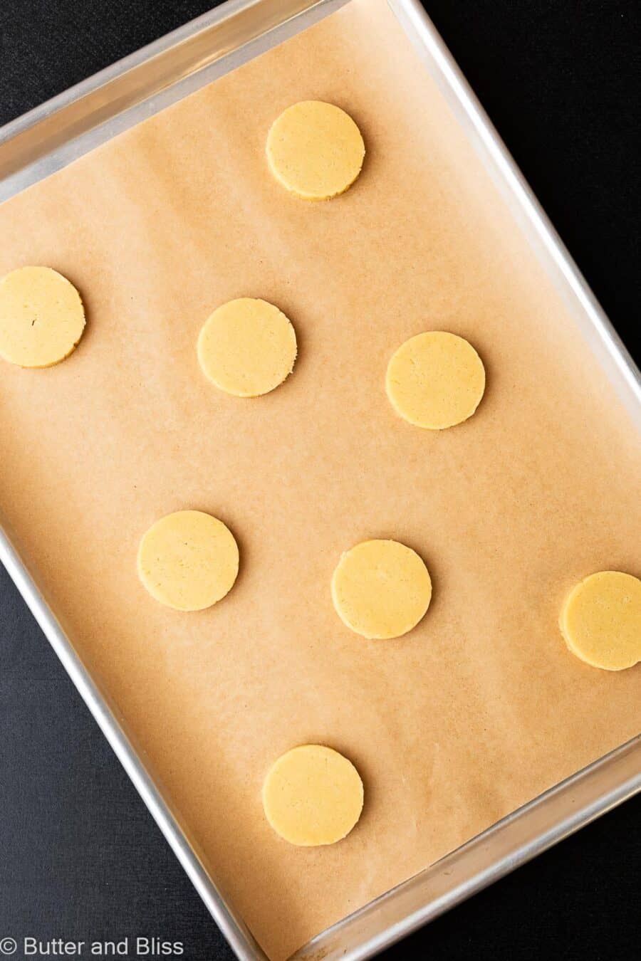 Slice and bake butter cookies on a parchment lined baking sheet, ready to be baked.
