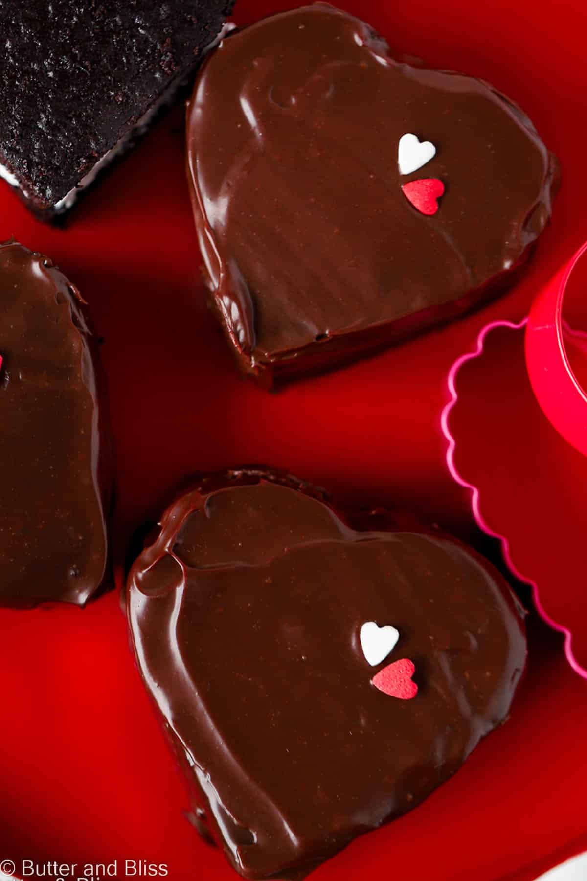 Mini chocolate marshmallow heart cakes arranged on a red platter.