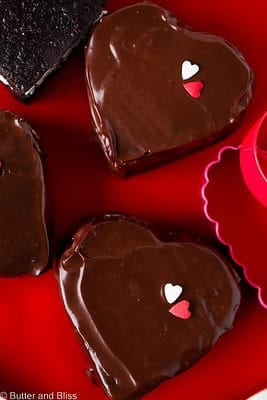 Mini chocolate marshmallow heart cakes arranged on a red platter.
