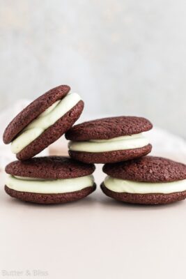 A small batch of chocolate mint whoopie pies in a pretty stack on a table.