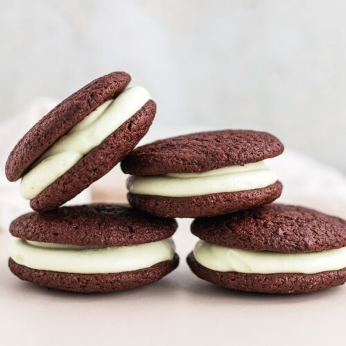 A small batch of chocolate mint whoopie pies in a pretty stack on a table.