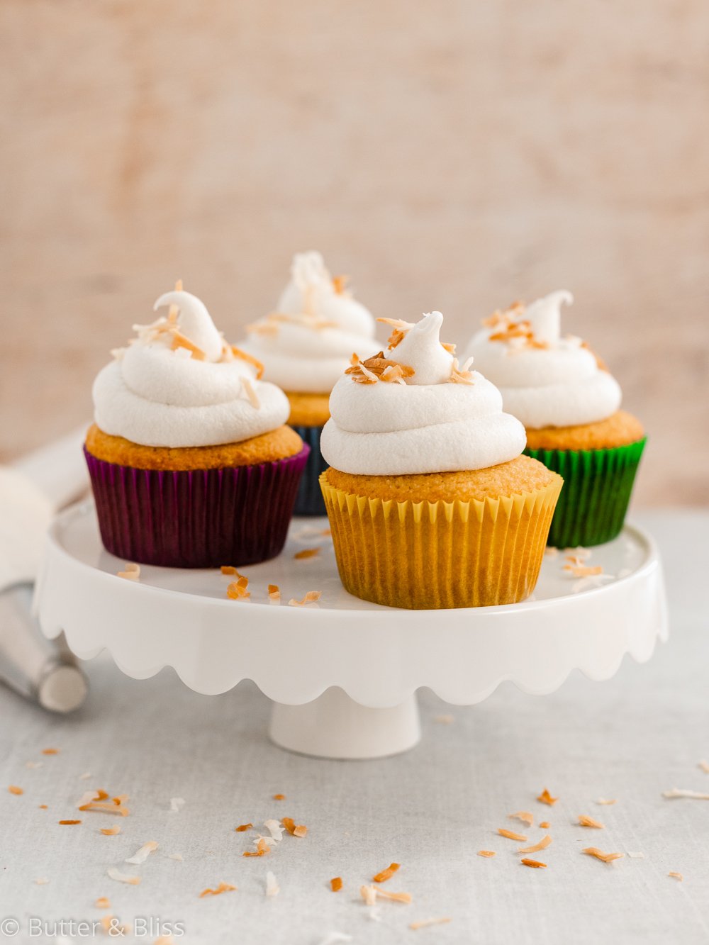 Frosted vanilla and coconut cupcakes on a platter