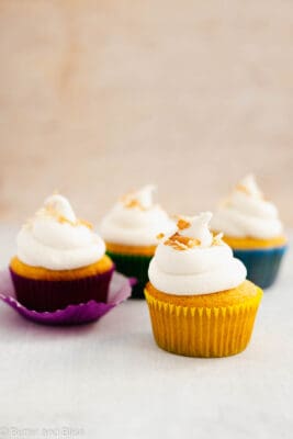 Gluten free vanilla cupcakes with vanilla icing arranged on a table