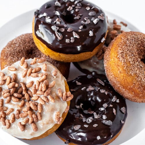 Platter of baked pumpkin donuts with assorted toppings
