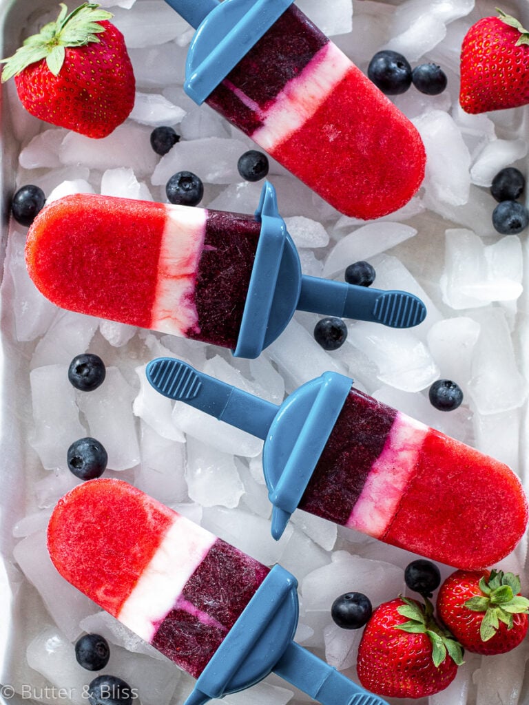 Sparkling berries and cream popsicles on a tray of ice