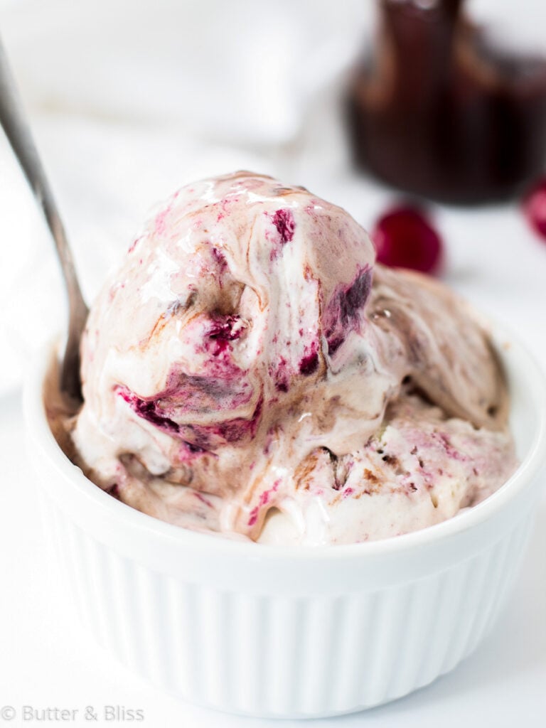Cherry swirl ice cream in a bowl with a spoon