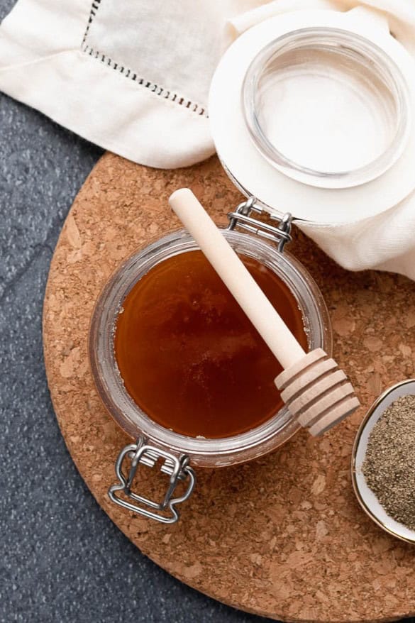 Honey in a glass jar with honey spoon.