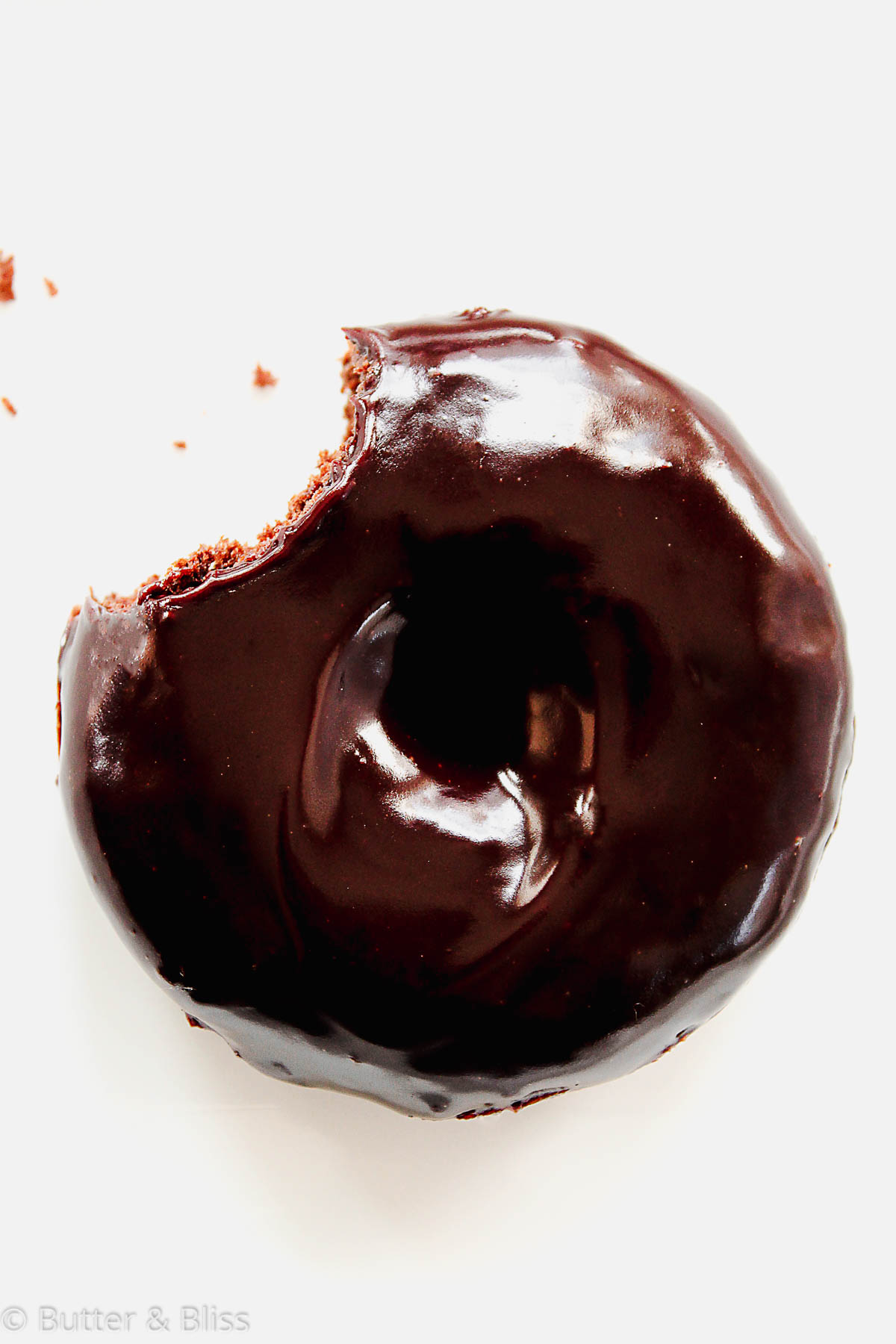 Chocolate glazed donut with a bite