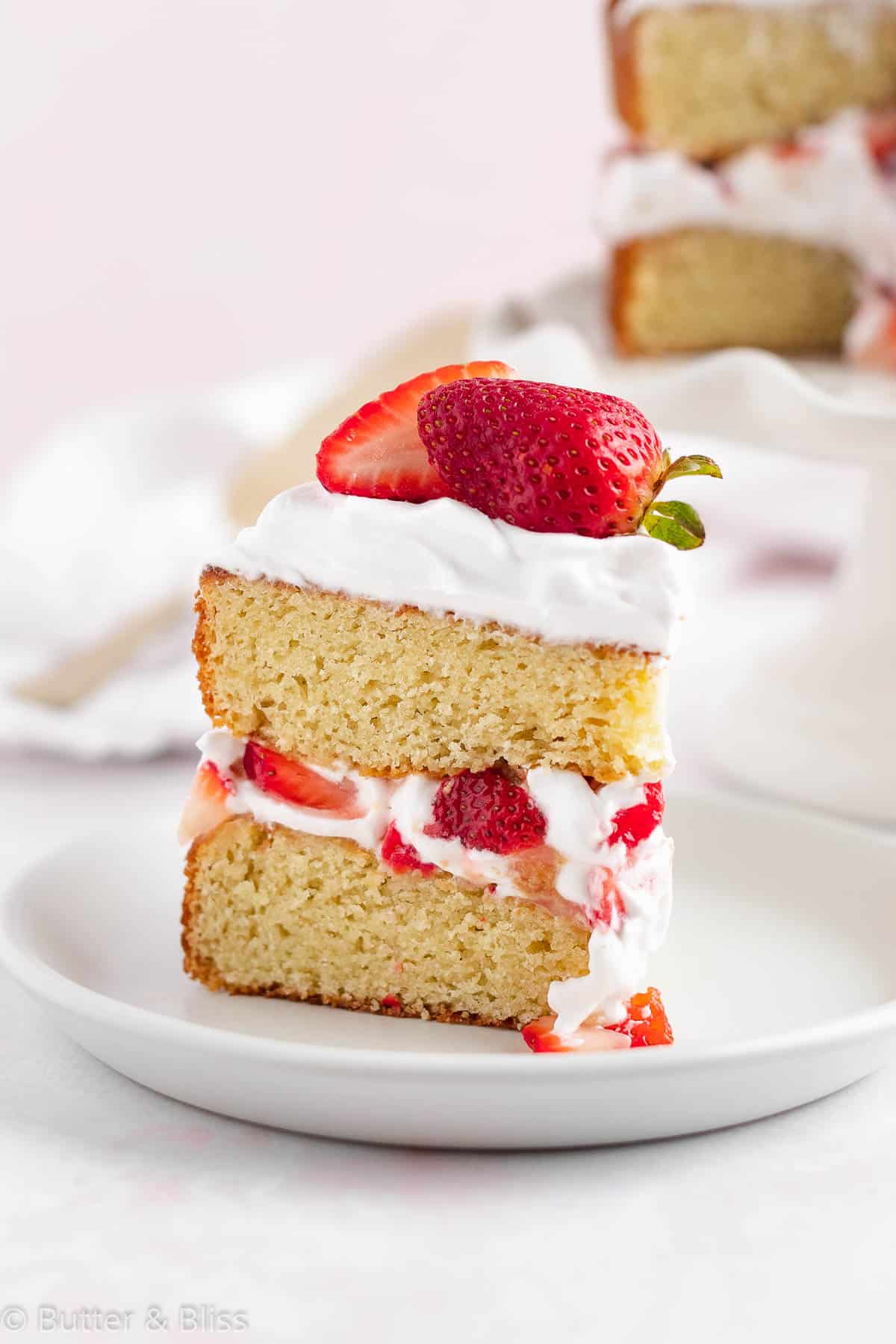 Slice of fresh strawberry shortcake cake on a plate for a delicious spring dessert recipe