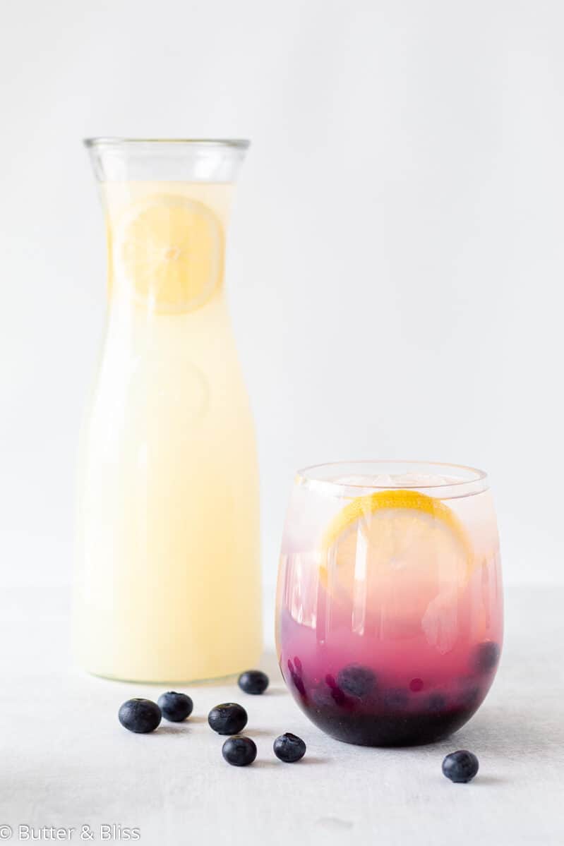 Glass and pitcher of blueberry lemonade