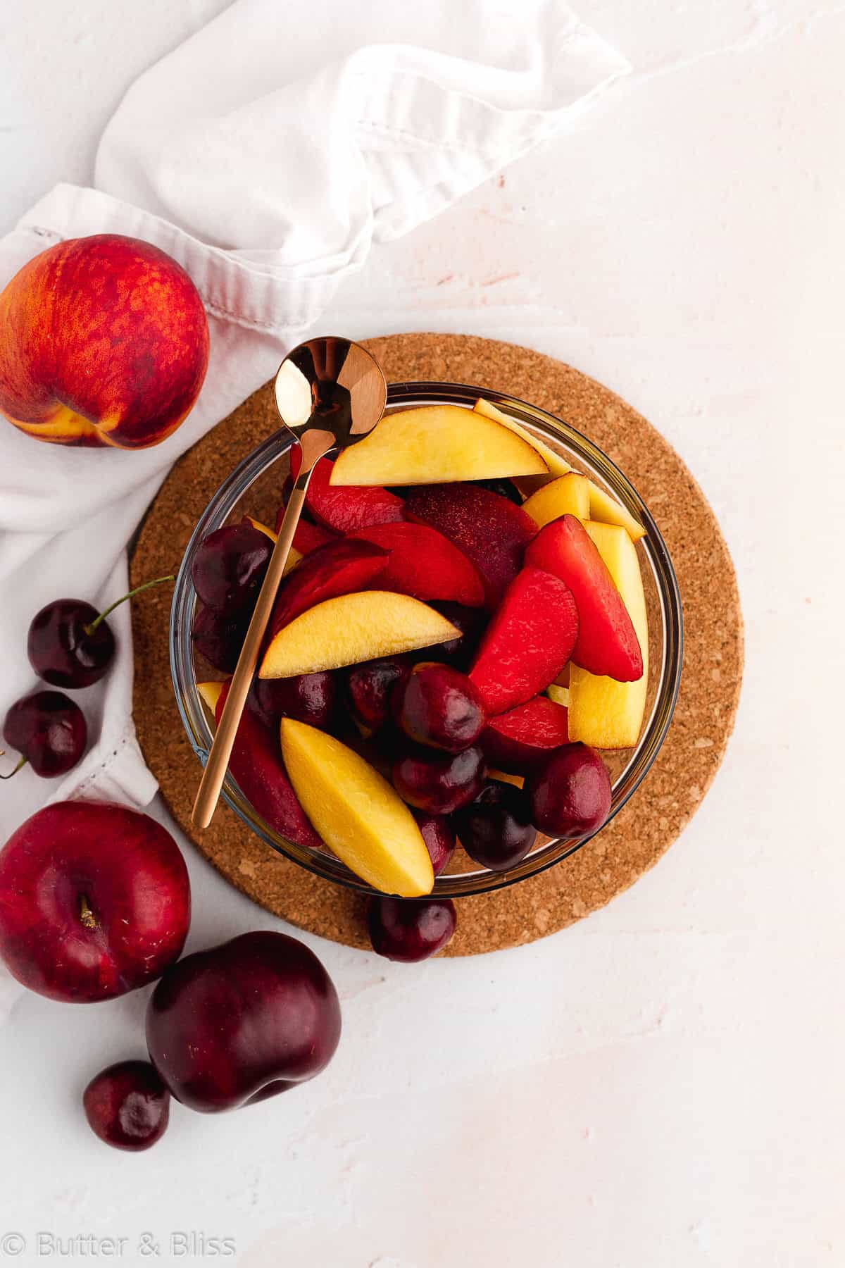 A pretty bowl of summer fruit cut into thick slices.