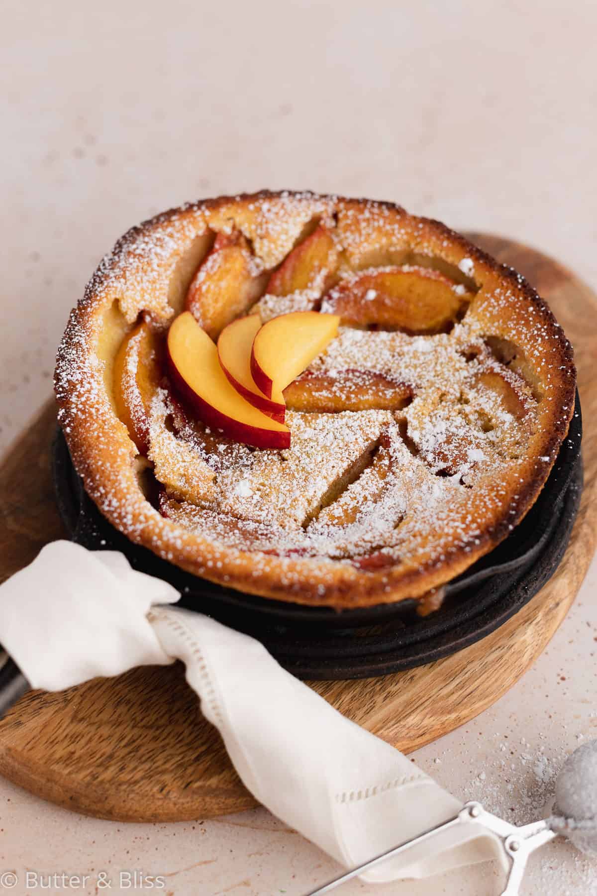 Peach clafoutis in mini cast iron skillet with powdered sugar