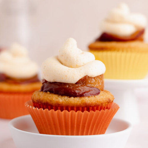 Single peach cupcake with peach frosting and caramelized peaches