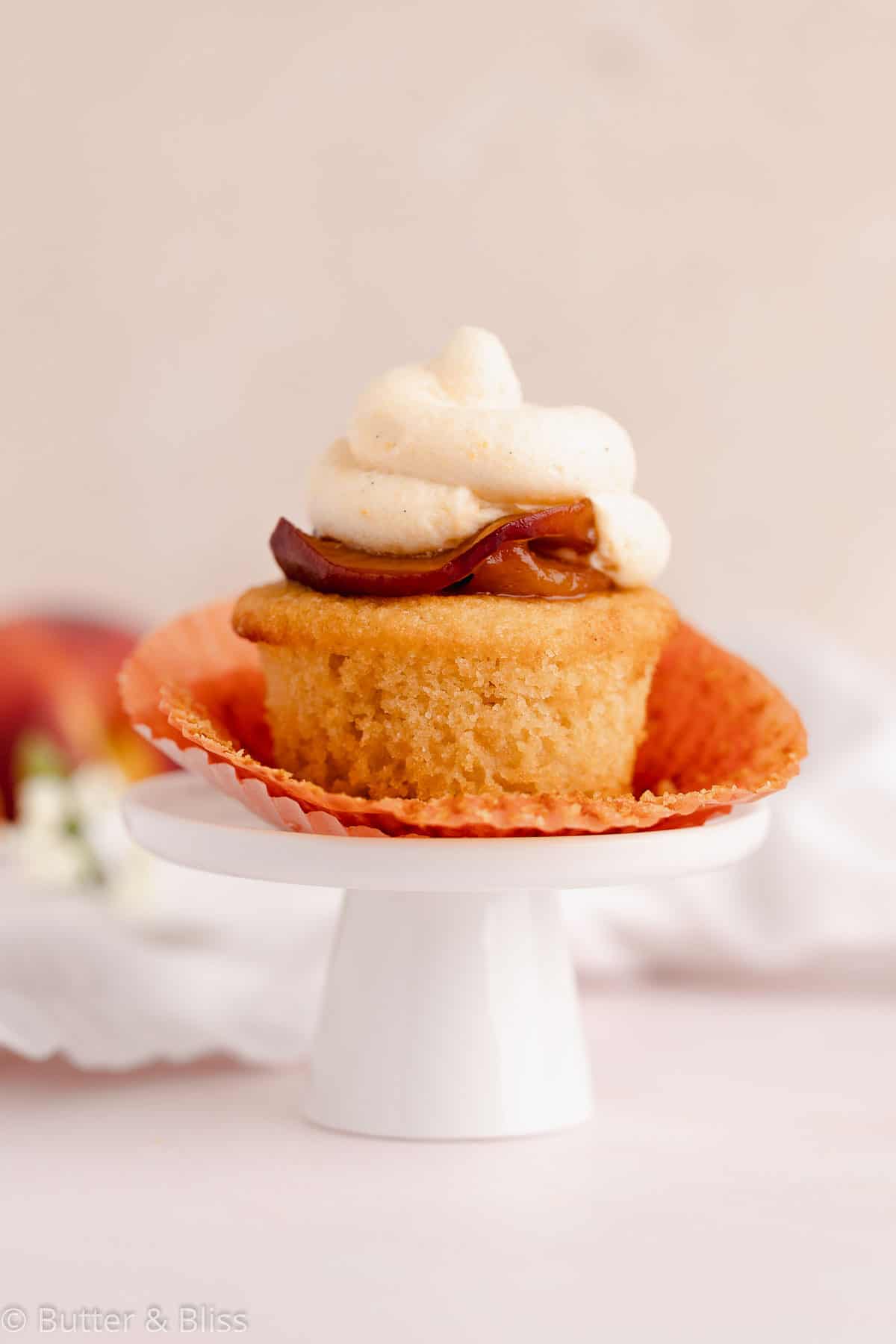 Frosted peach cupcake on a mini cupcake stand