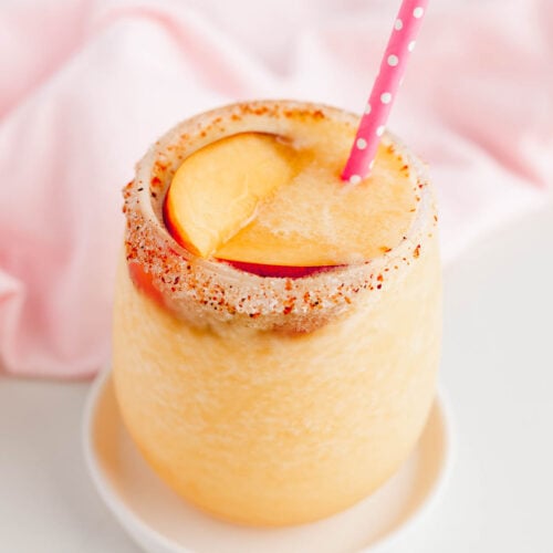Frozen peach and citrus refresher in glass with straw