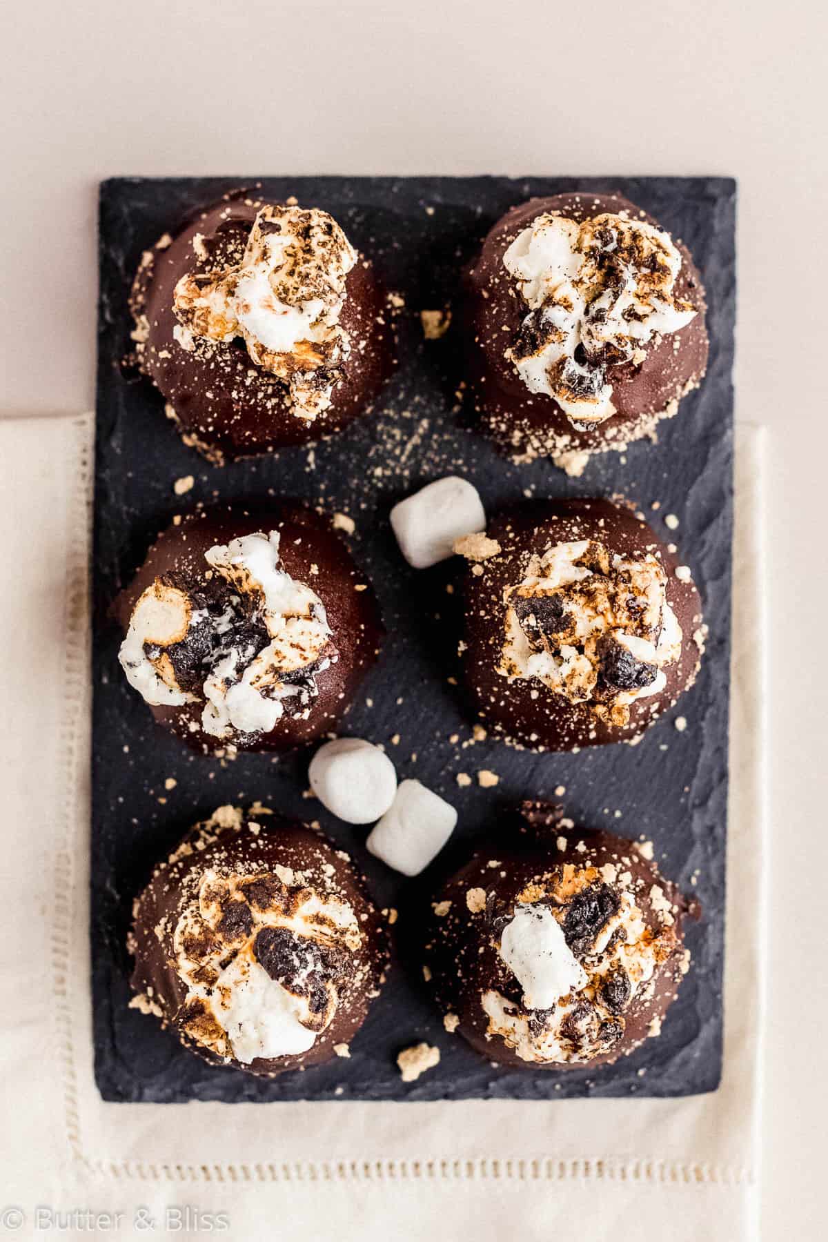 Toasty s'mores truffles lined up on a small plate