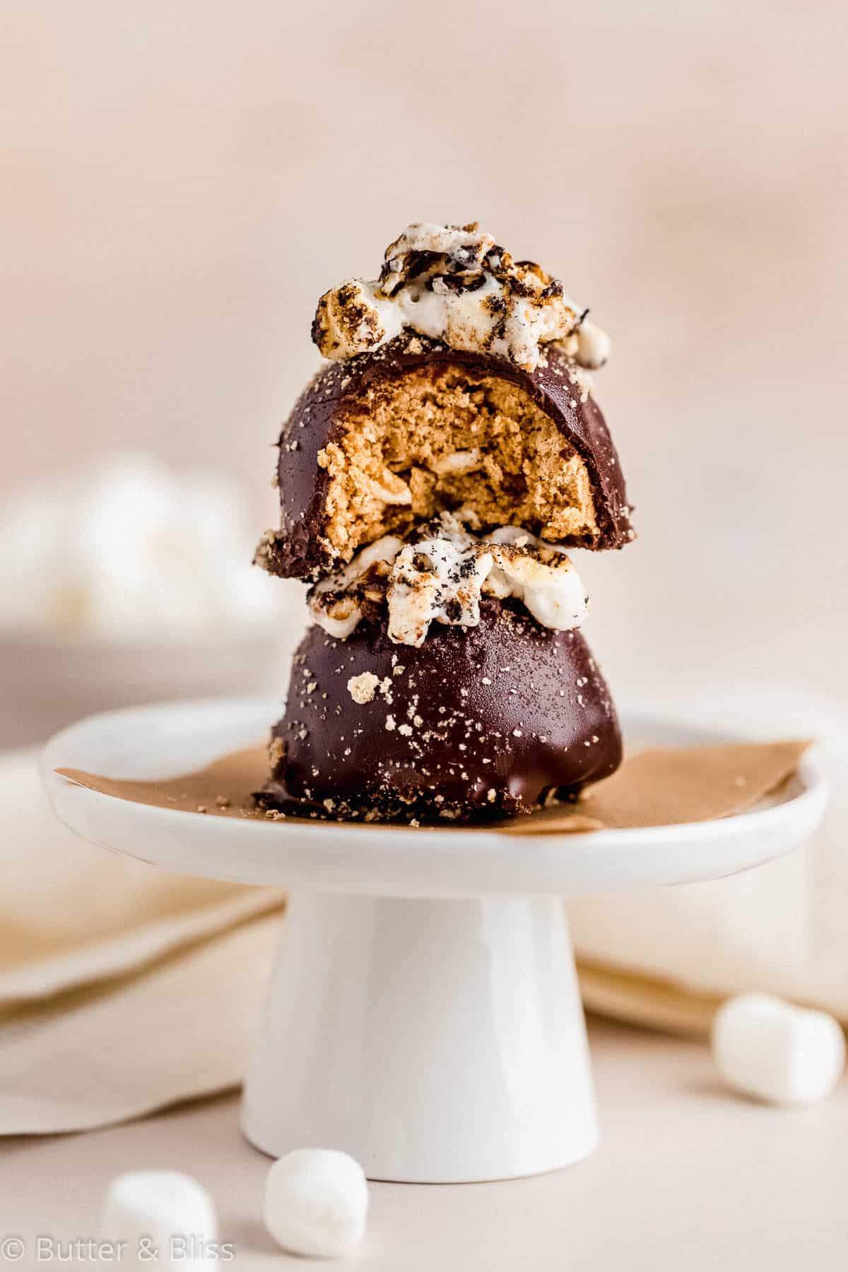 Two toasty s'mores truffles stacked on a small cupcake stand