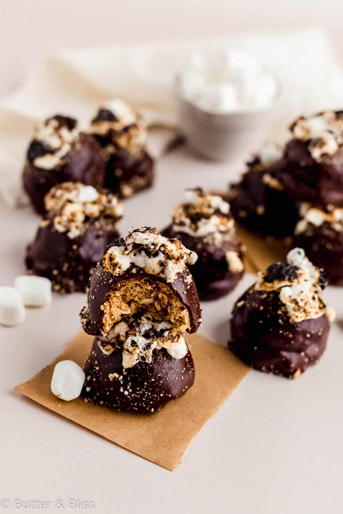 Toasty s'mores truffles with toasted marshmallow tops spread on a table