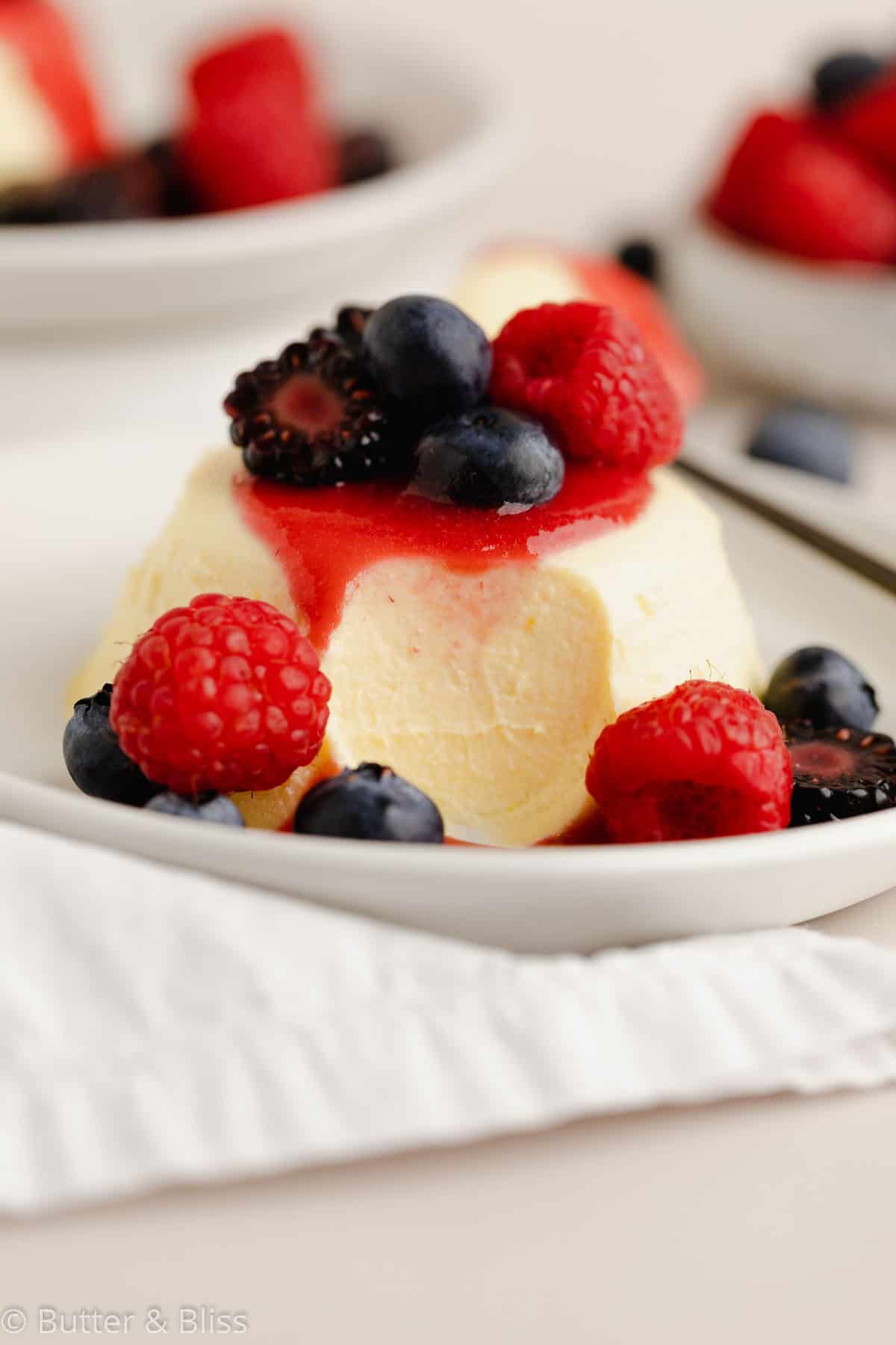 A bite of panna cotta with summer berries for a labor day dessert.