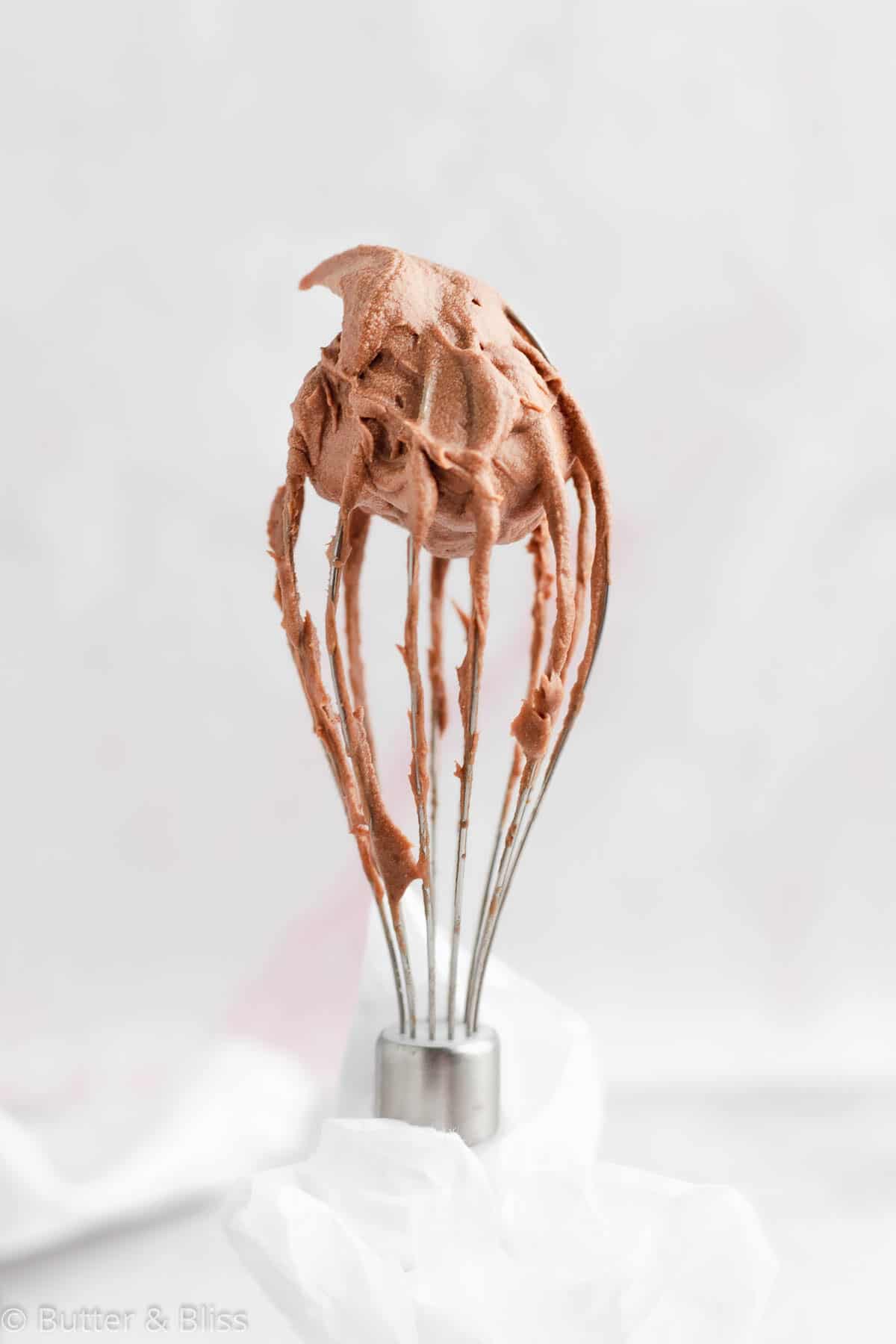 Dairy free chocolate frosting on a whisk