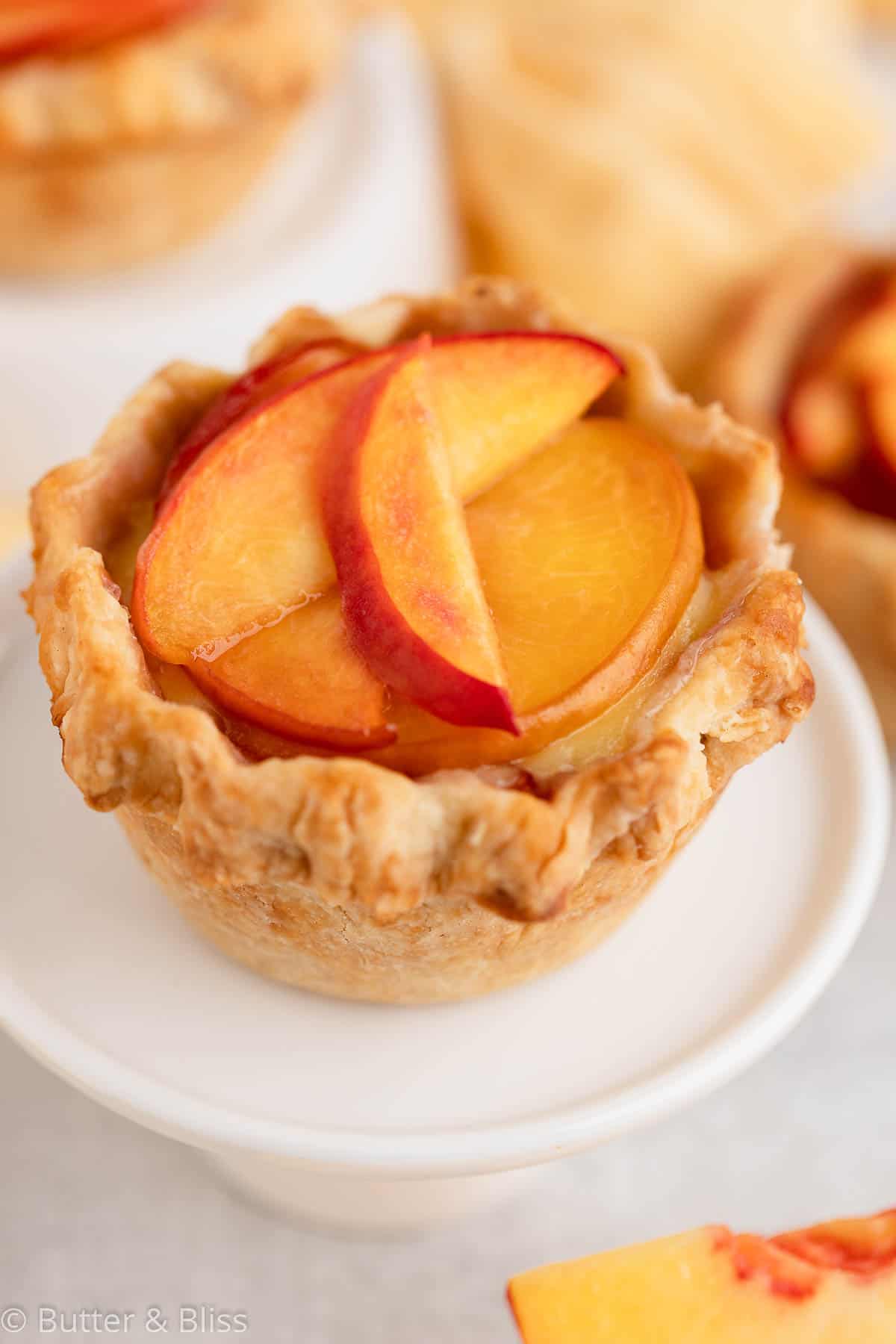 Mini peach pie on a small cupcake stand for end of summer labor day desserts