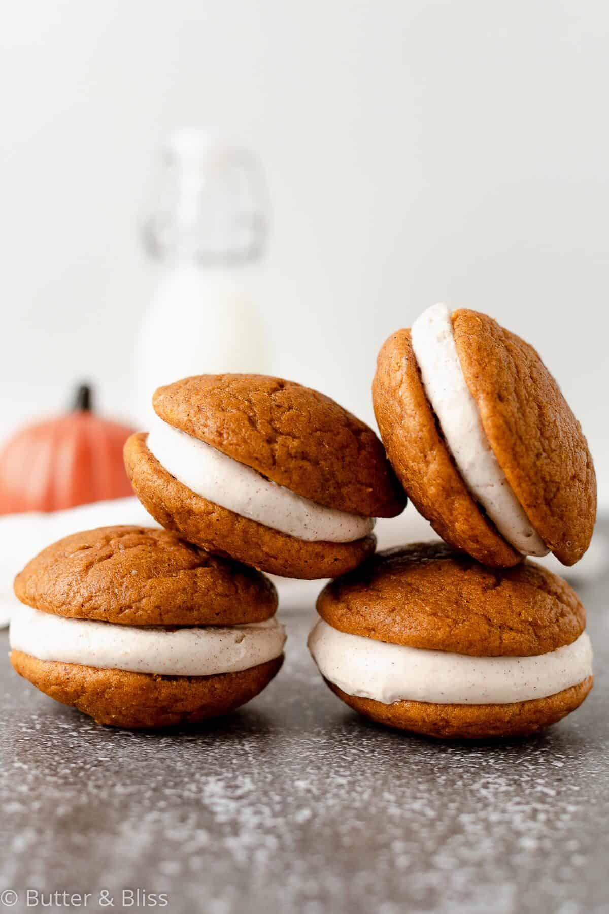 Pumpkin whoopie pies with cream cheese filling stacked in a pyramid