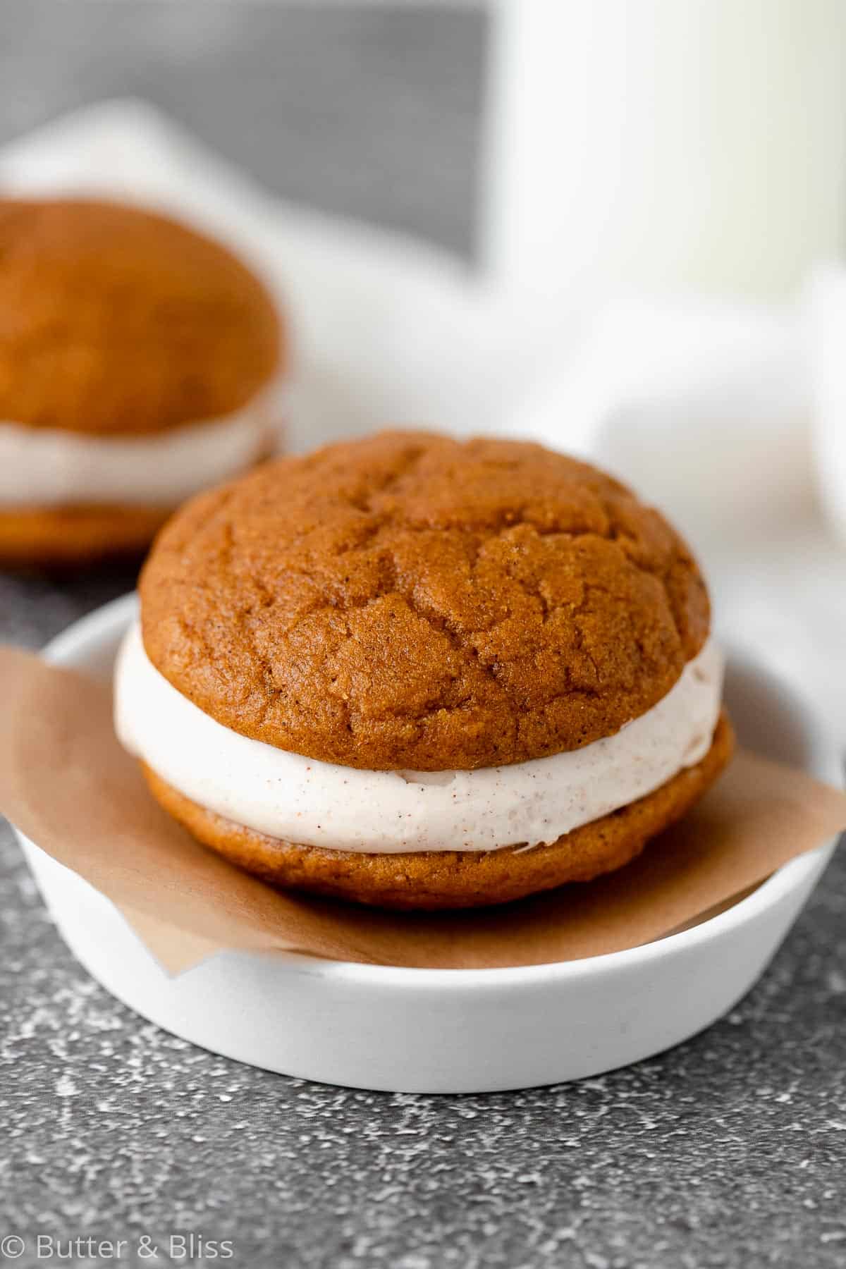 Close up of a single pumpkin whoopie pie on a small plate