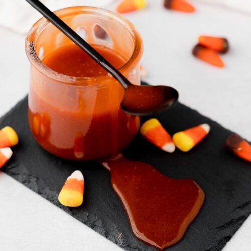 Candy corn caramel sauce in a small jar with a spoon