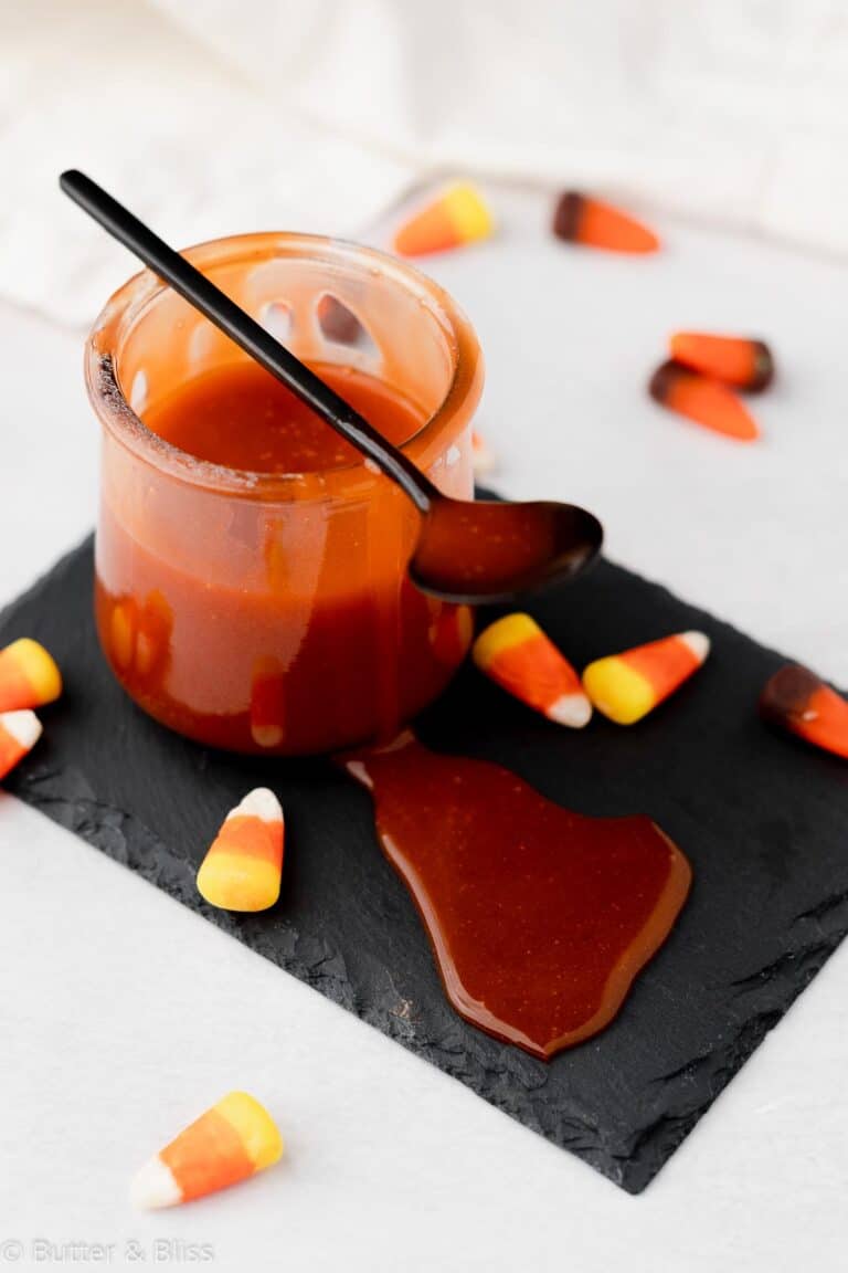 Candy corn caramel sauce in a small jar with a spoon