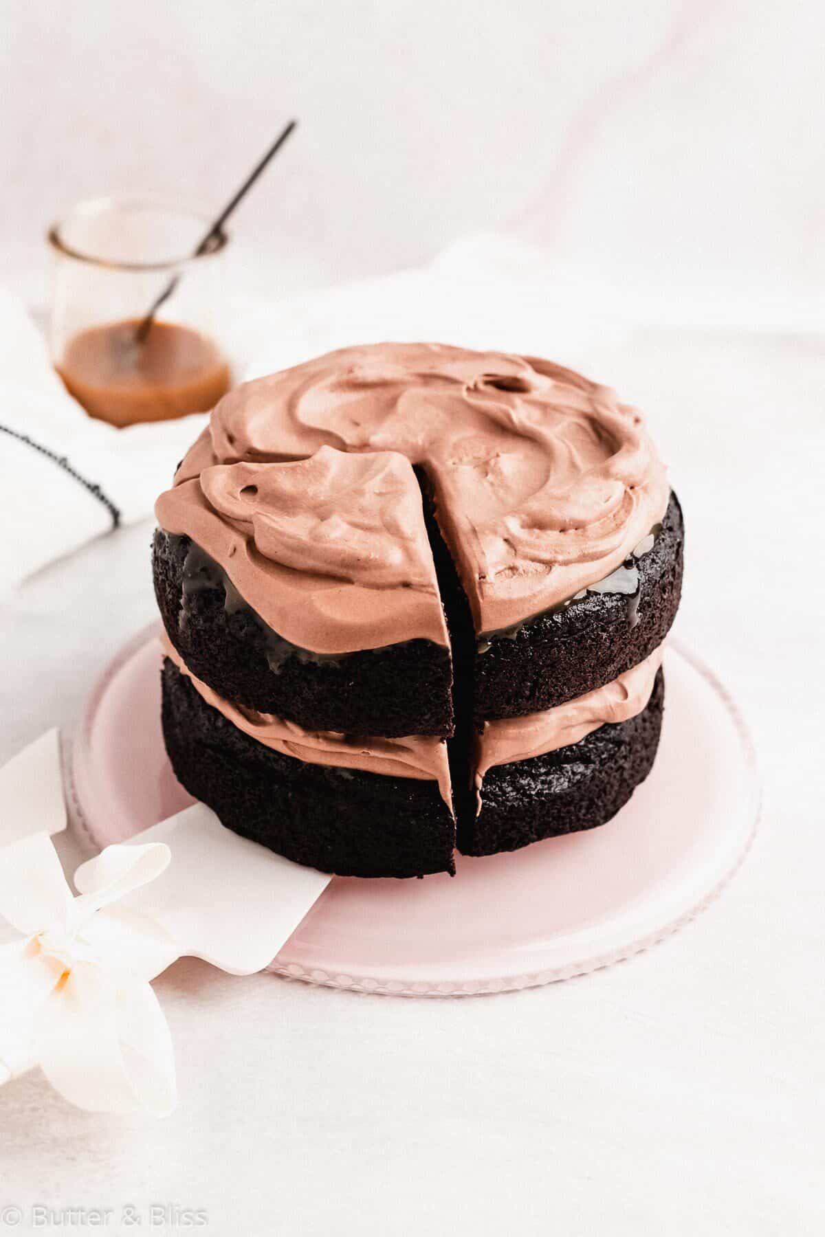 A classic mini chocolate layer cake with chocolate whipped cream on a platter.