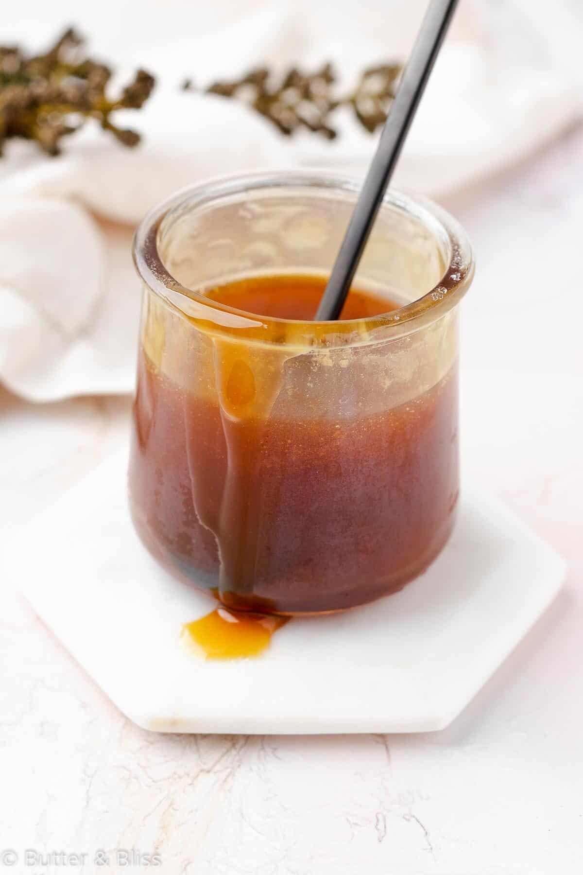 Maple syrup caramel sauce dripping down a small jar