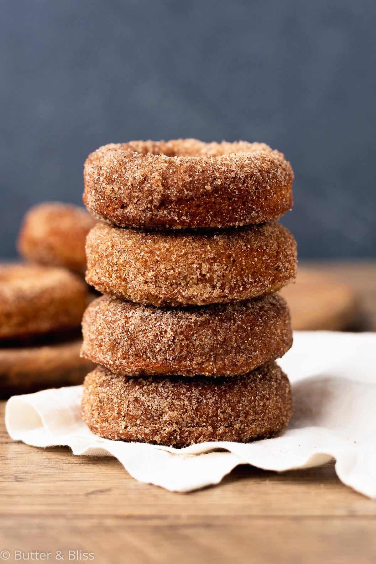 Apple cider donuts in a stack on a table.
