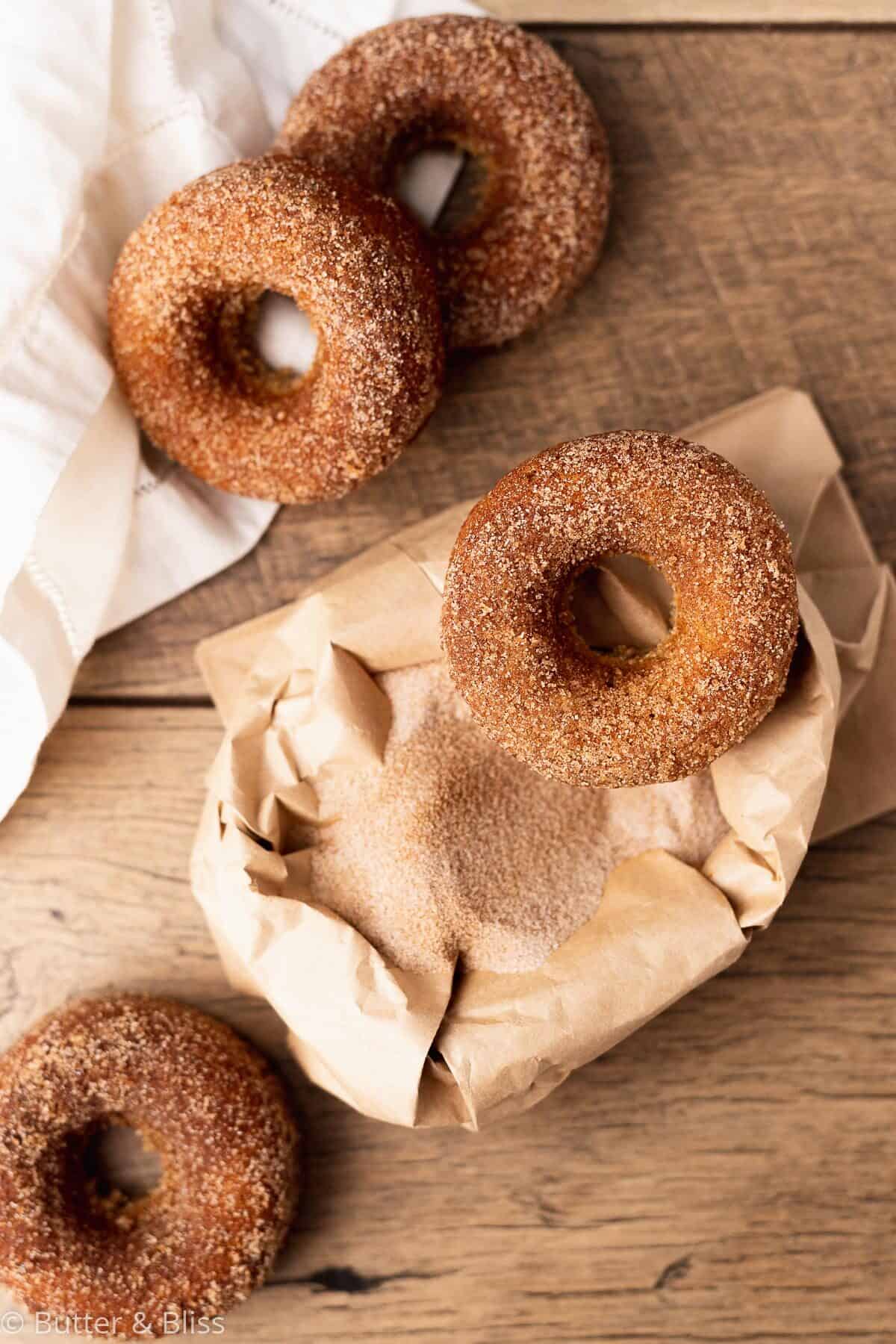 Gluten free apple cider donuts with cinnamon sugar on a table