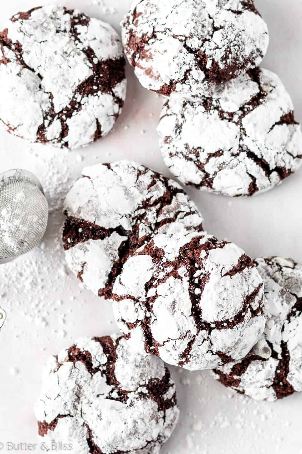 Chocolate crinkle cookies arranged on a table.