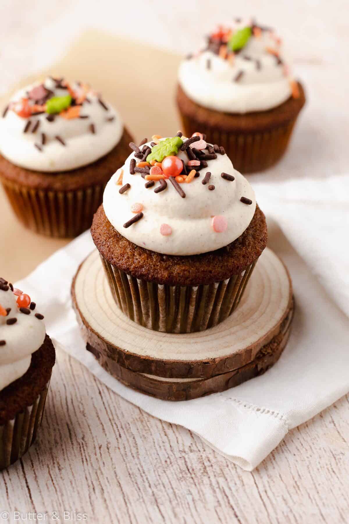 Frosted gluten free spice cupcakes on small wooden plates