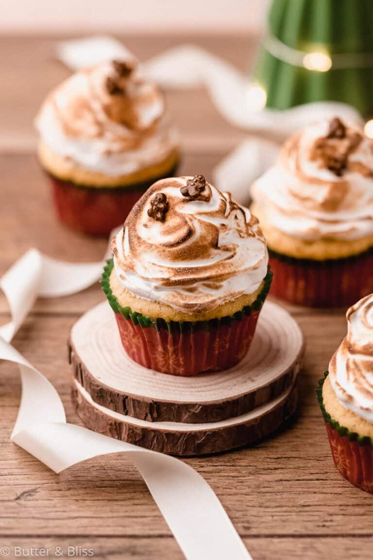 Eggnog cupcakes with marshmallow frosting arranged on a table.